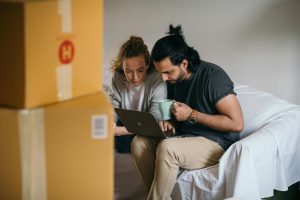 young couple in new home looking at laptop