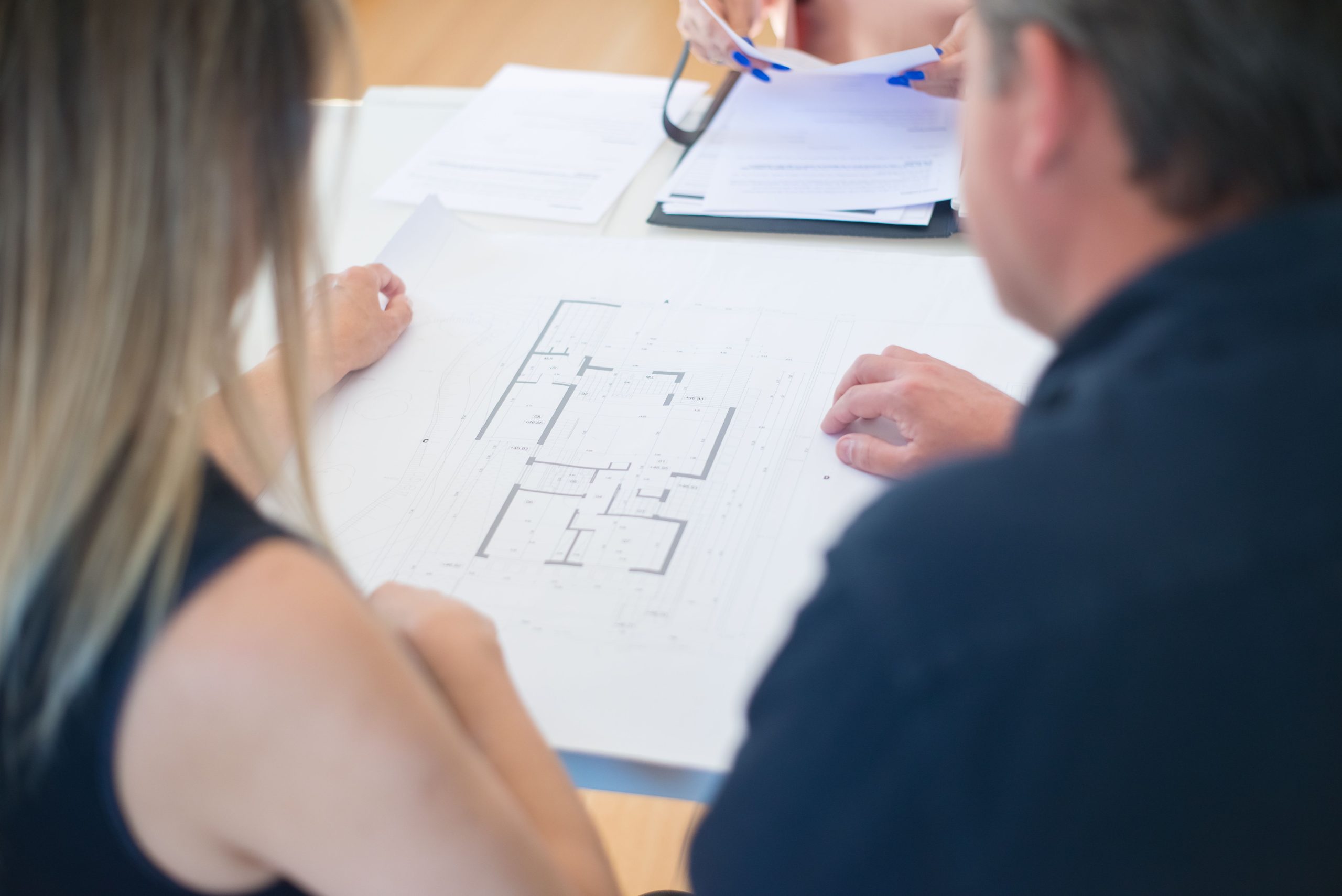 Couple reviewing a house floorplan together at a table.